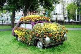 Car covered in flowers and plants.